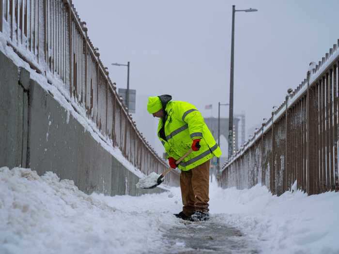 A New York City worker shovels snow.