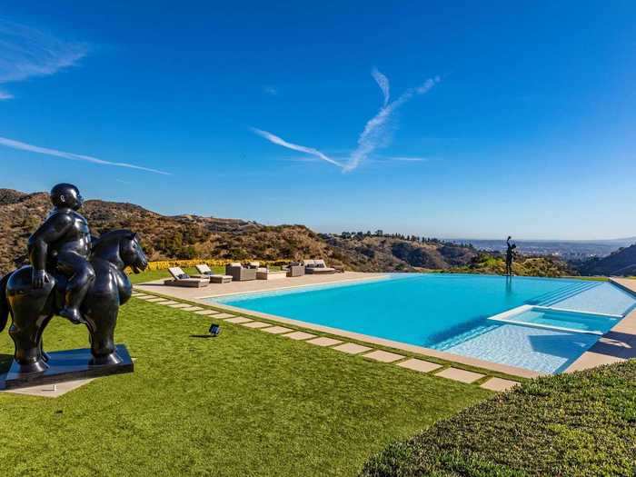 The infinity pool, which is surrounded by pool furniture and a fire pit, has a sculpture of the fictional character Rocky Balboa on one side. Hilton adds that the pool has a built-in spa.