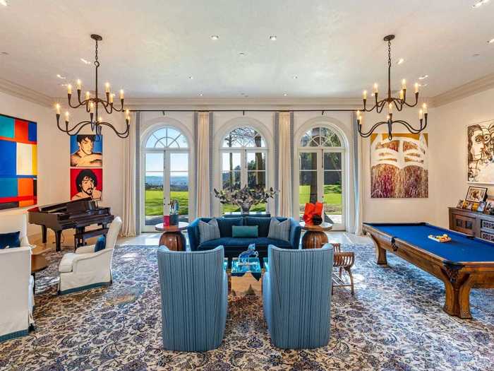 According to Hilton, the Mediterranean-style home has eight bedrooms, 12 bathrooms, and a massive living room with a pool table, "Rocky" pop art, and floor-to-ceiling windows.