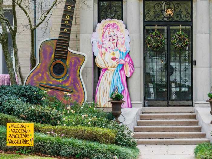 This Dolly Parton-themed house float features a sign that says "vaccine, vaccine, vaccine, vacciiiine," a play on Parton