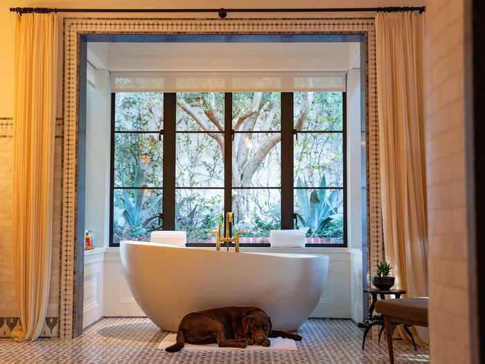 Listing photos show a lavish bathroom with a freestanding soaking tub.