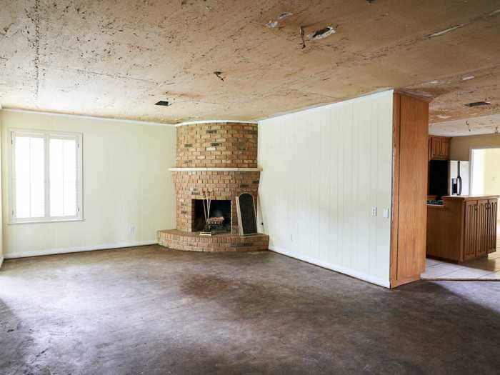 The flooring, walls, and fireplace in the living room looked dated.