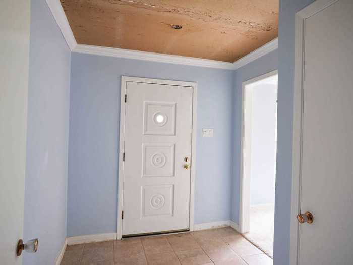 Before the renovation, the entryway had light-blue walls and a dated doorway.