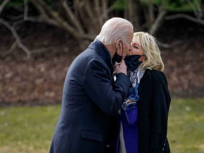 They pulled down their face masks for a kiss as Joe boarded Marine One in January 2021.