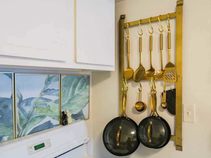 In the kitchen, Abraham stores some of her dishes vertically by hanging them up.