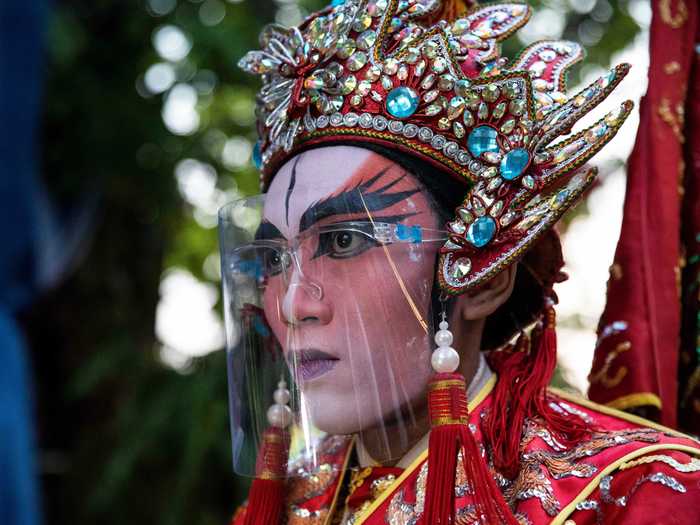 Chinese opera troupe members wore face shields over ornate make-up for performances.