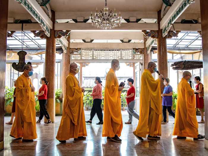 Buddhist monks and visitors alike wear protective gear to prevent the spread of the coronavirus.