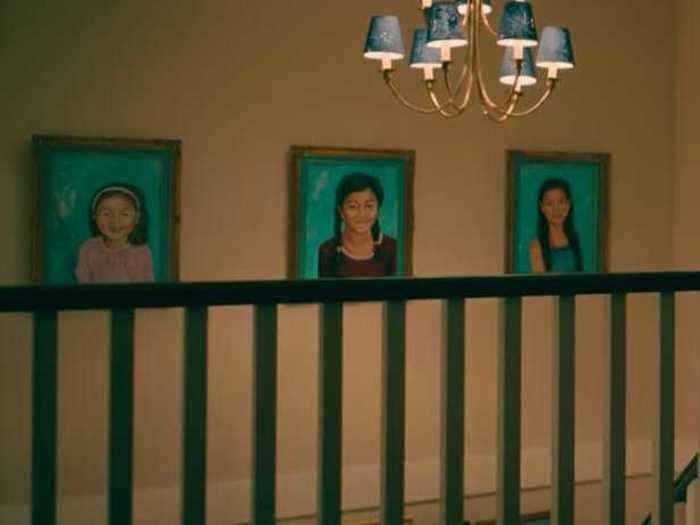 The paintings above the stairs are visible in each movie.