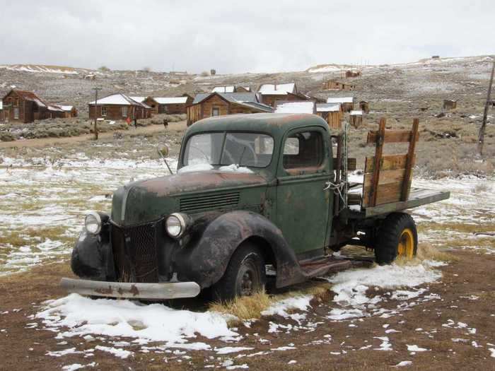 Old vehicles and the wooden wagons and sleds that were used to transport gold from the mines litter Bodie