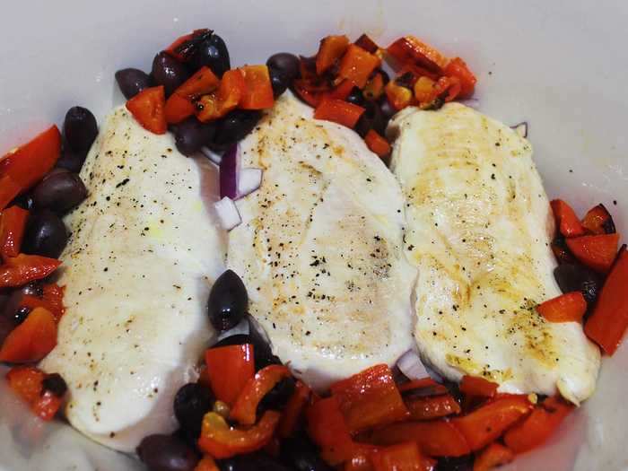 I lightly browned three boneless, skinless chicken breasts and arranged them in the slow cooker with Kalamata olives, my roasted red peppers, and chopped red onion.