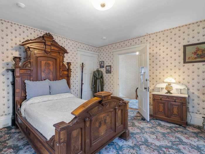 The bedrooms all have floral wallpaper, ornate dressers, and large wooden headboards. A less-conventional decor choice? Photographs of Lizzie.