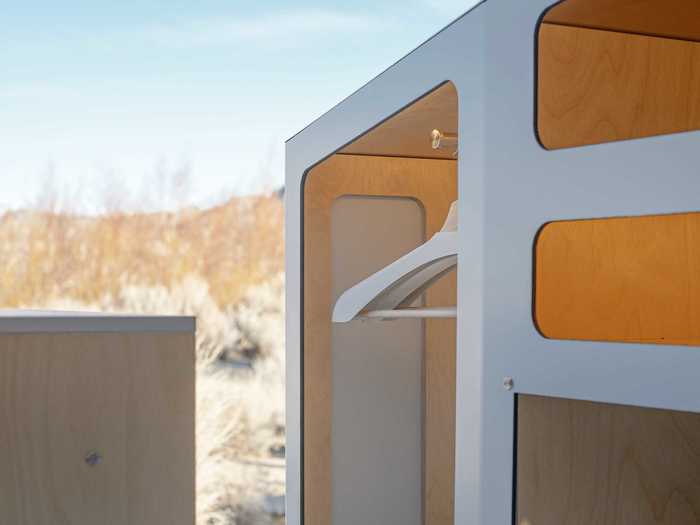 There are also several storage units throughout the tiny home on wheels, including a small closet with a clothes bar.