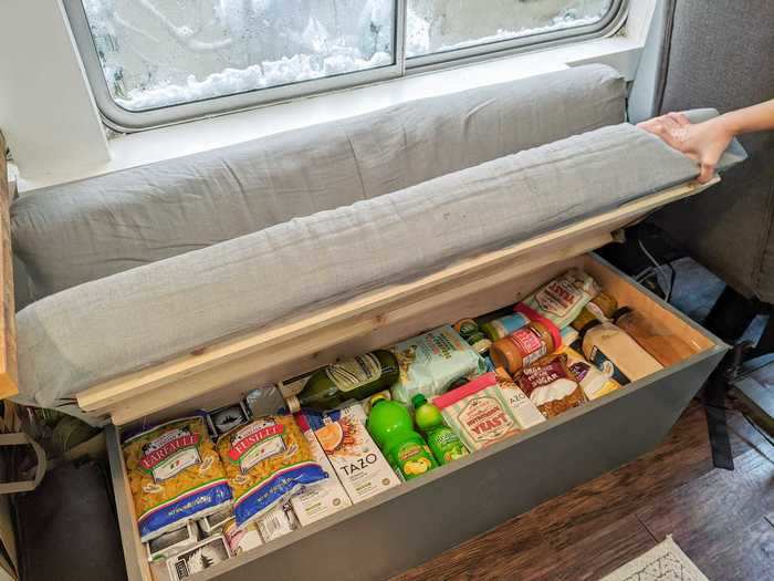 Under their cushions, the couches double as storage. One serves as a pantry while the other holds shoes and off-season clothing.