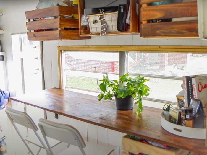 Bree Contreras lives in an RV with their partner and dog, and they installed storage crates on the walls above their workspace.