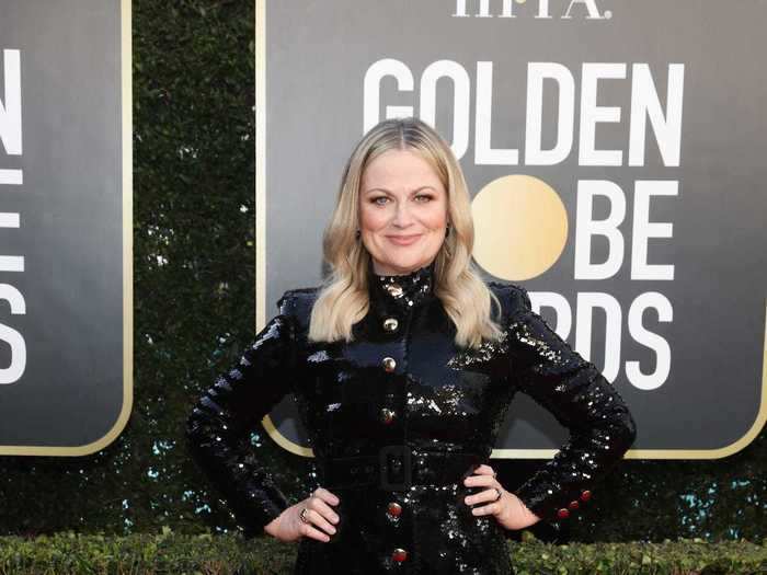 Amy Poehler sparkled in a short black dress with gold buttons running down the middle.