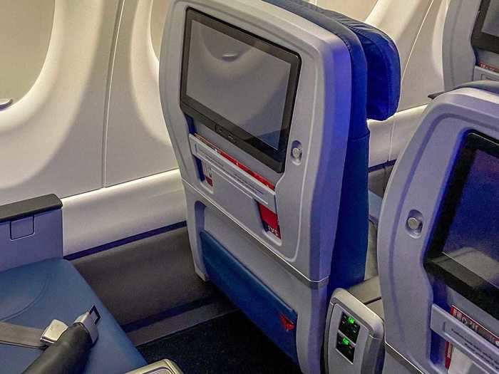 These seats also feature passenger-facing coat hangars, USB charging ports, and 110v AC power outlets, along with a larger in-flight entertainment screen.