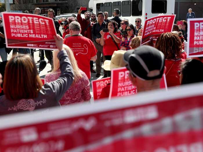 Healthcare workers rallied to support their fellow medical professionals to protest pay cuts and demand more personal protective equipment as hospitals braced for an influx of COVID-19 patients.