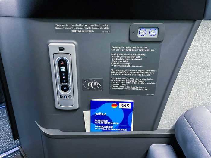 Standard seat amenities are also included like a tethered remote to control the in-flight entertainment...