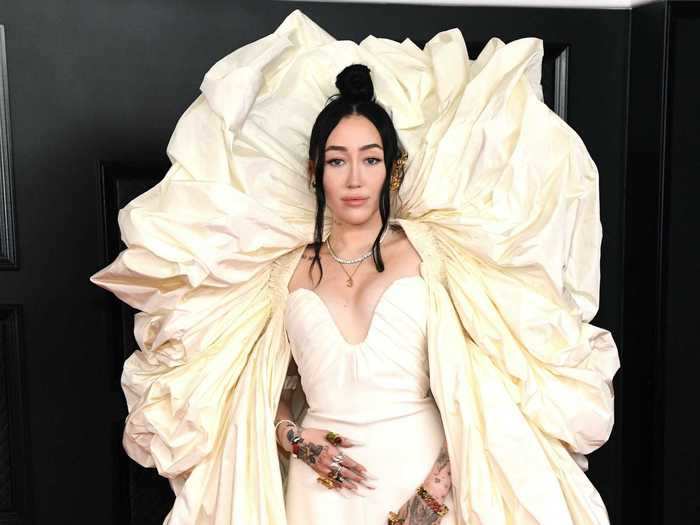 Noah Cyrus opted for a cream-colored gown with a giant fabric arch that extended above her head.