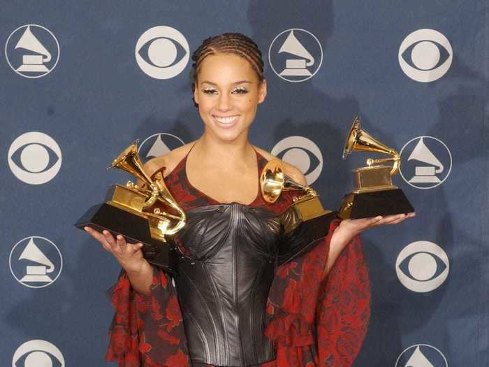 March 2002: Alicia Keys rocked a flowing black and red dress with a leather bustier and coordinating slouchy boots as she smiled with her five awards.