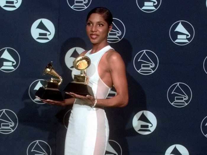 February 1997: Toni Braxton accepted two Grammy awards in a sporty white gown detailed with mesh panels along each side.