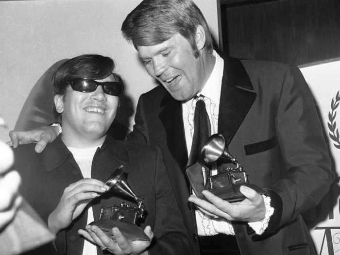 March 1969: Glen Campbell stands with fellow Grammy-winner Jose Feliciano looking put-together in his suit and tie.