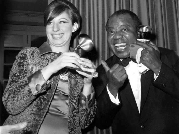 April 1965: Louis Armstrong looked sharp in a beautifully tailored tux while posing with his Grammy - and Barbra Streisand.