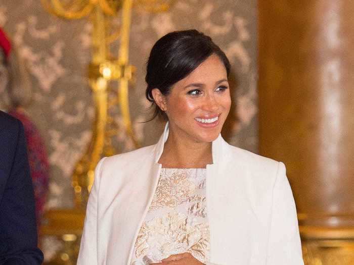 Back at Buckingham Palace, she wore a silver brocade dress with gold floral embroidery and a cream coat by Amanda Wakeley.