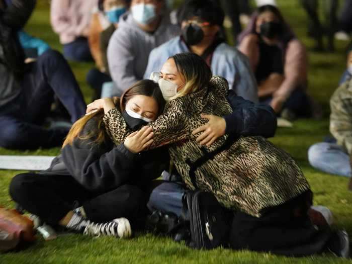 At the rally, people embraced one another, placed flowers, and lit candles around the vigil.