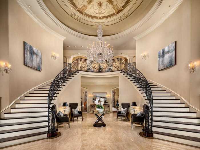 Upon entering the main residence, visitors step into the foyer, which has two staircases, a grand chandelier, and vaulted ceilings.