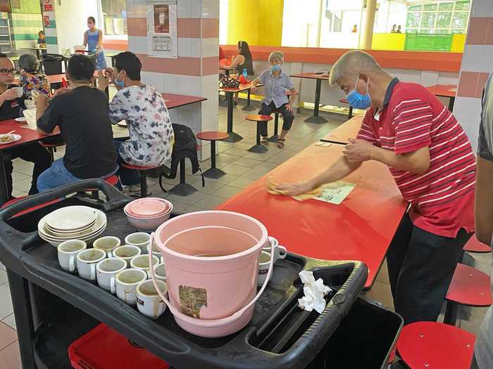 Employees are constantly making the rounds through the hawker centers to keep the tables clean.