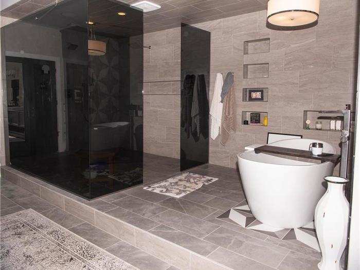 The attached master bathroom has a bathtub and a large shower.