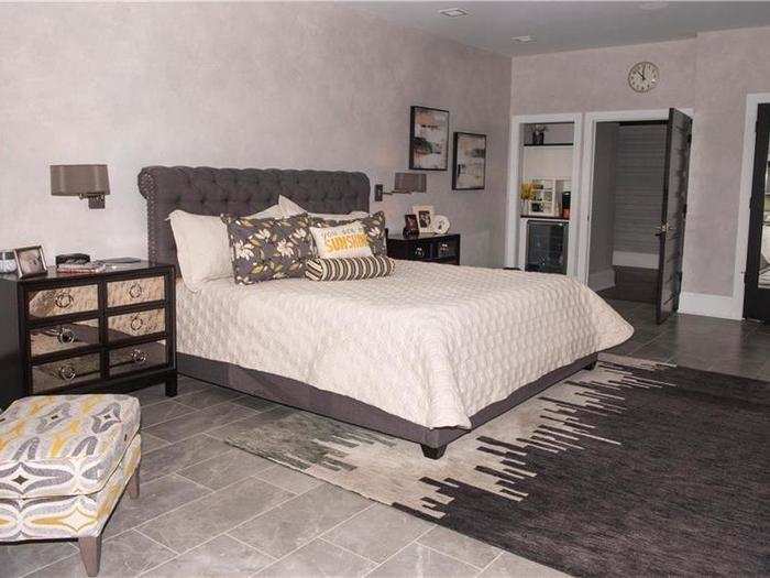 The master bedroom has enough space for a large bed, a closet, and a seating area.