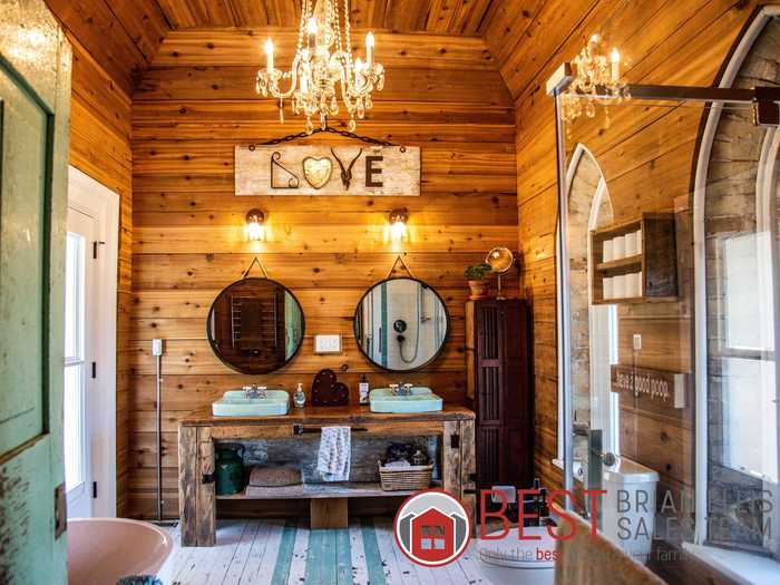 The master bathroom includes a vintage chandelier and sinks.