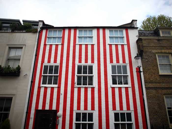 A London resident painted this house red and white after her neighbors prevented her from demolishing it.