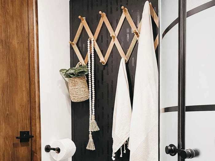 Upstairs, the bathroom has a shower and a hanging rack above the toilet for more storage.