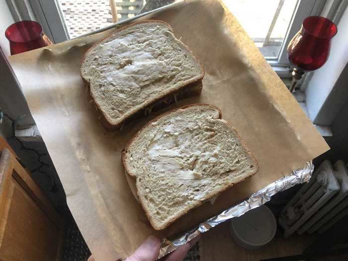 Next, I placed the sandwiches on the air fryer tray and buttered both sides.