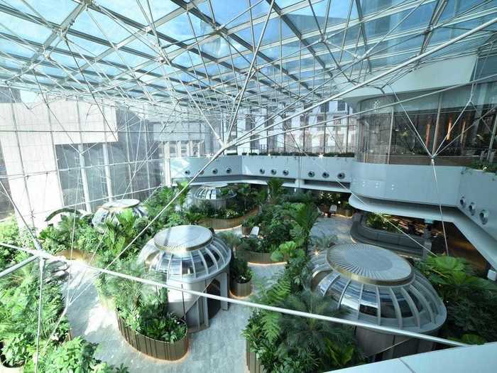 The Citigold Centre is a large glass-walled atrium with meeting pods, a cafe, and an abundance of greenery.