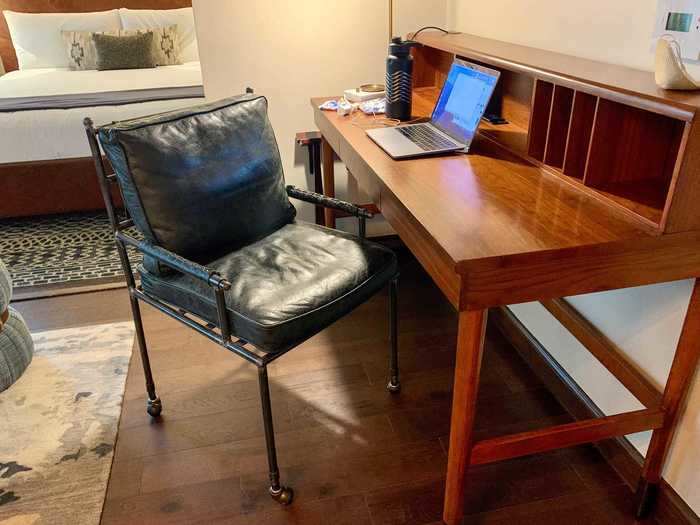 Here, the two-tiered desk came with built-in outlets, an overhead TV, a thick cushioned seat, and a lamp similar to the one I have at home.