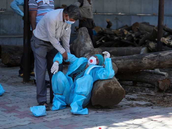 Families mourn the loss of their loved ones while donning medical gear and PPE as infection still runs rampant.