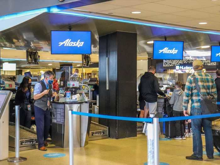 Social distancing floor placards guided the path towards check-in desks, which were fitted with plexiglass partitions.