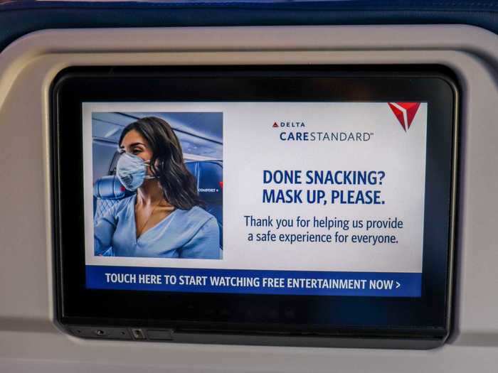 Seat-back entertainment screens showed health and safety reminders during boarding. I hadn