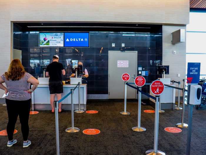 The gate had the same setup of social distancing measures as check-in including floor placards, mask reminders, plexiglass partitions, and hand sanitizer.