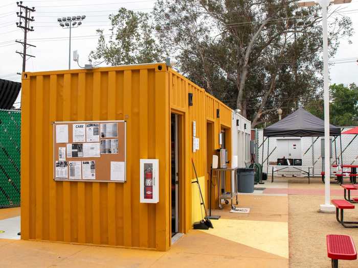 From there, I turned the corner and was immediately greeted by the line-up of tiny homes, an outdoor seating area, and shipping container-like buildings.