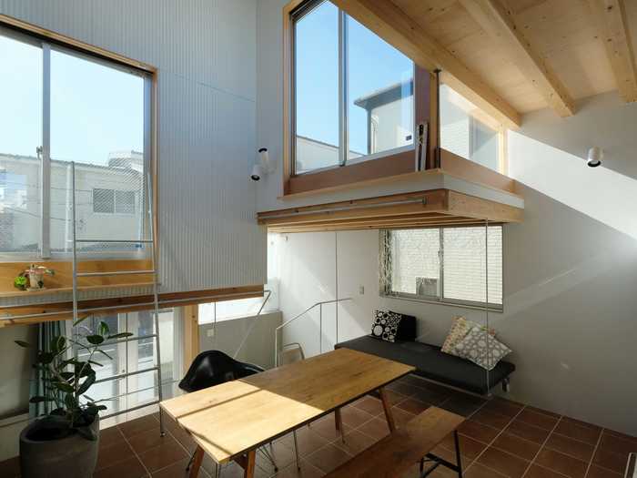 The upper living space - accentuated by staggered ceilings - includes the dining room and kitchen.