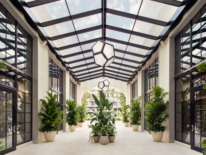 Walking into the hotel, visitors pass through an airy entryway filled with tropical plants.