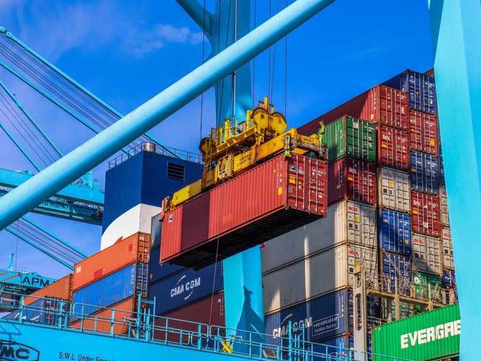 The longshoreman then lowers the crane, aligning the container with the truck below.