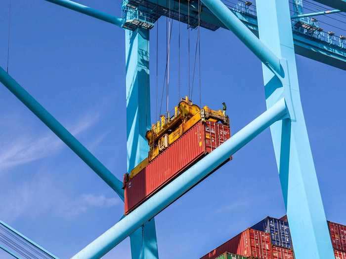 The massive containers are quickly whisked through the air by the crane as if weightless.