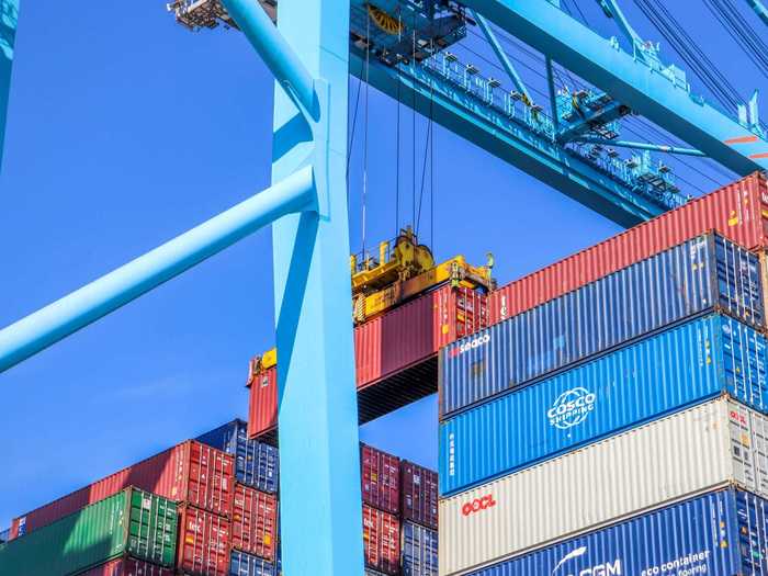 Containers are plucked from the ship by a crane that