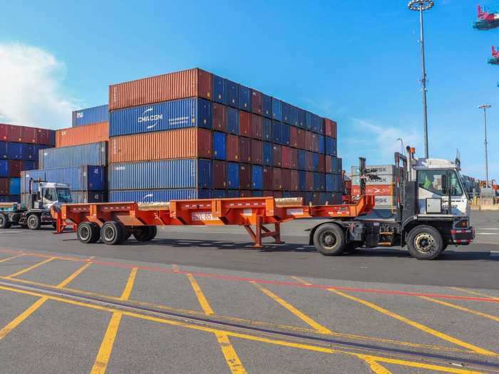 During offloading, a constant flow of these intermediary trucks approach the ship to receive containers.